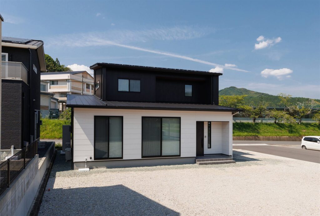 ブラックの玄関ドアにレッドシダー。真庭市の回遊動線がある2階建て