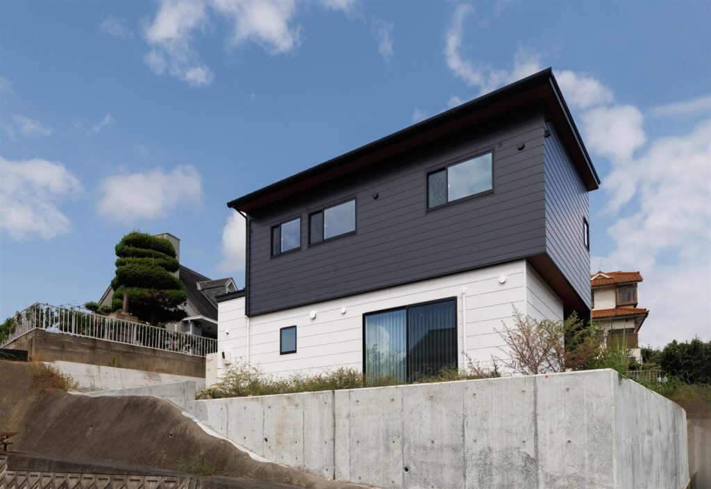見晴らしのよい傾斜地に建つ。津山市のモノトーンの2階建て